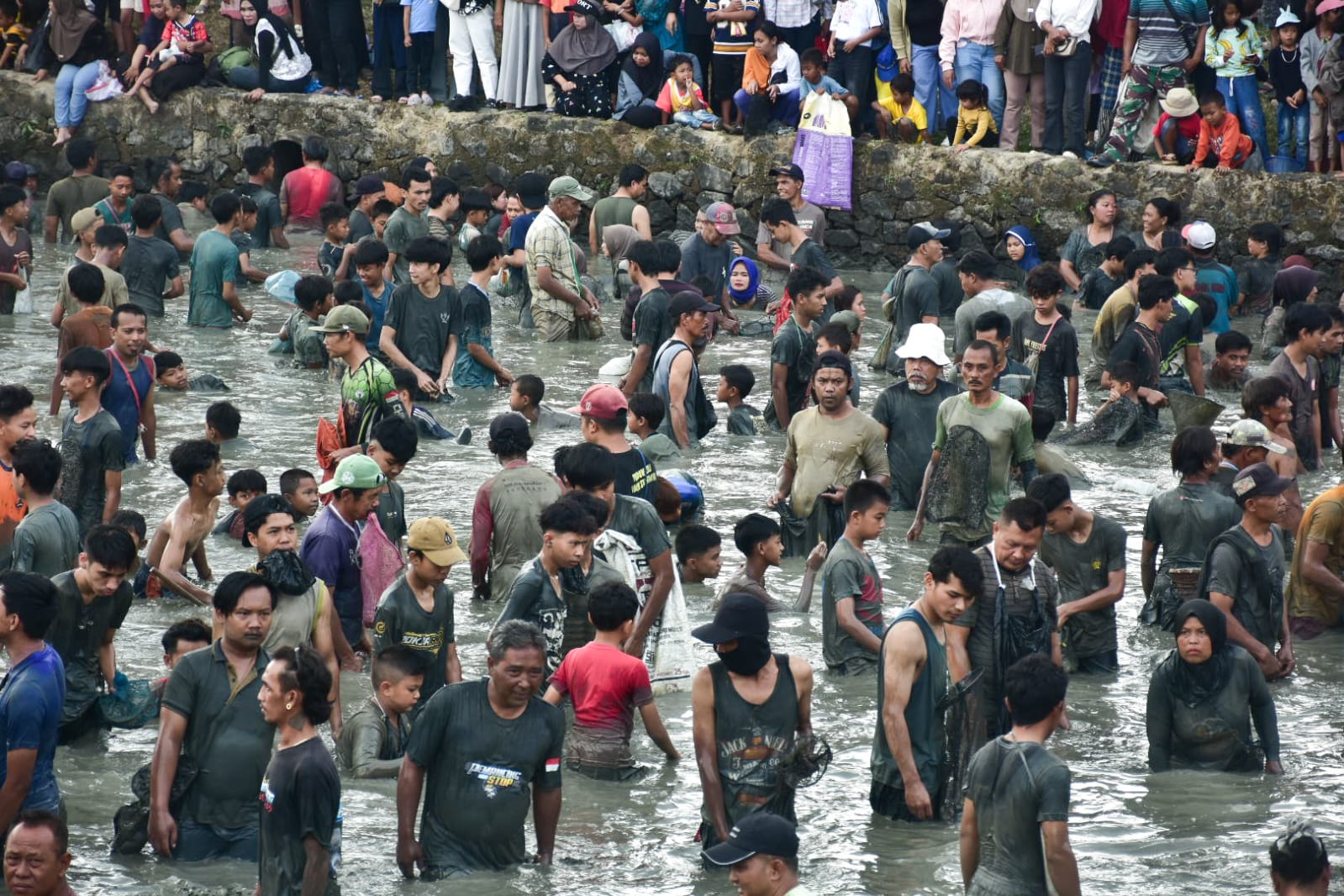 Ribuan warga menangkap ikan dalam tradisi ngagogo lauk di Kolam Masjid Al Kamil Sumedang.