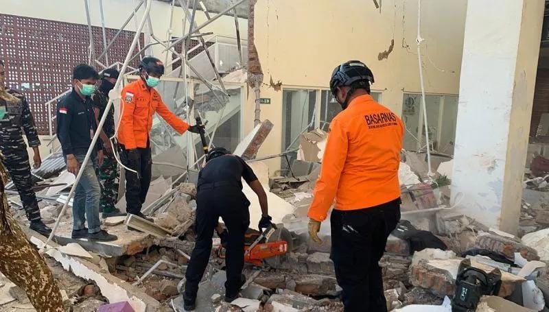 Personel Kantor SAR Maumere mengevakuasi korban bangunan roboh akibat guncangan gempa bumi. Foto: Antara