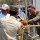 Petugas Satpol PP memasang garis pembatas di akses masuk area tambang PT Mas Putih Belitung, Kecamatan Pangkalan, Karawang.
