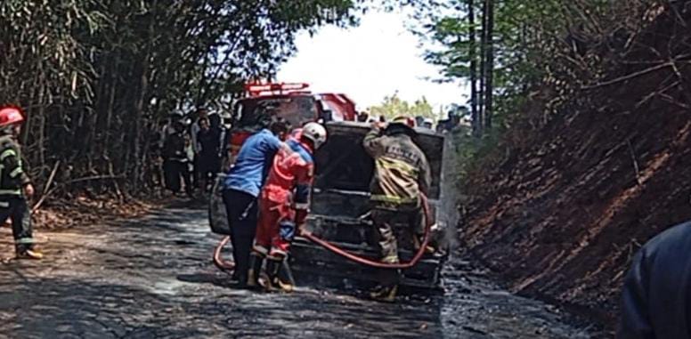 Petugas memadamkan Toyota Kijang yang terbakar di Jalan Setiawargi, Kelurahan Setiamulya, Kecamatan Tamansari, Kota Tasikmalaya.