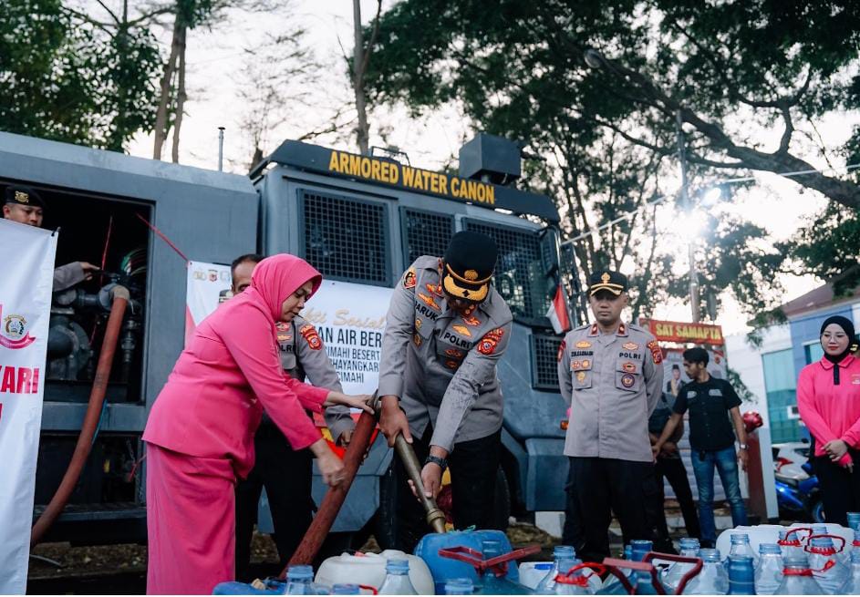 Personel Polres Cimahi menyalurkan air bersih menggunakan water cannon kepada warga terdampak kemarau.