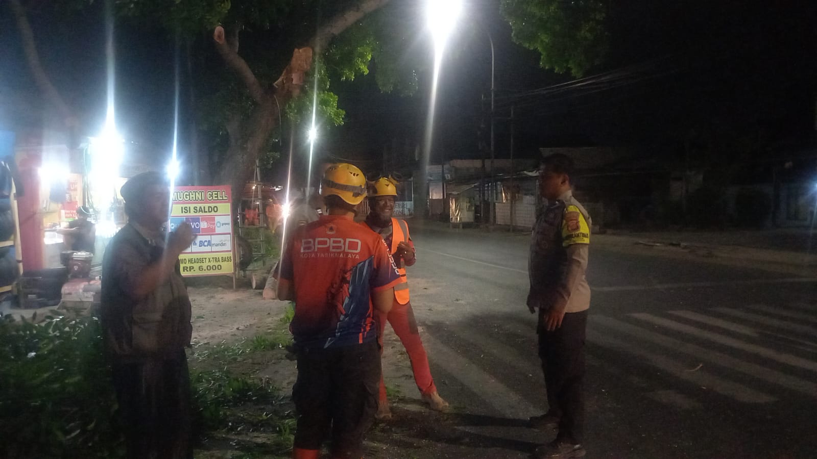 Petugas gabungan mengevakuasi pohon mahoni yang tumbang di Jalan Ir. H. Djuanda, Kota Tasikmalaya.